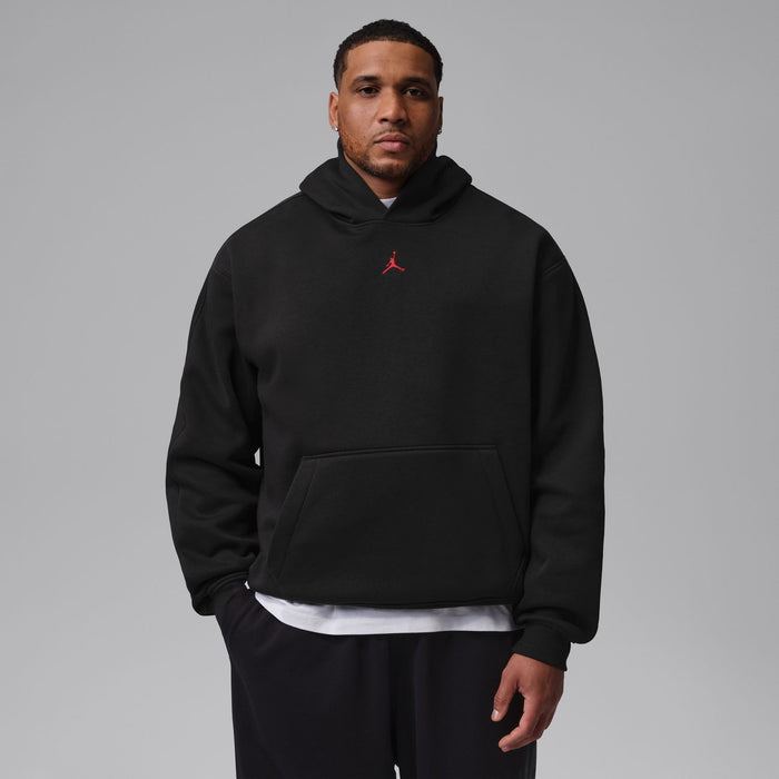Men's black pullover hoodie worn model, hood and front pocket visible; red Jumpman logo