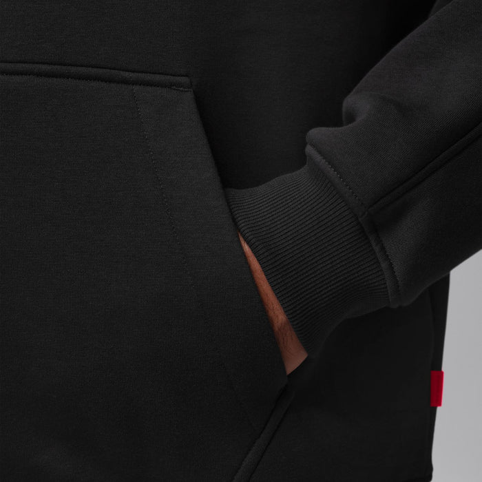 Men's black hoodie side seam and ribbed cuff detail; red interior fabric label