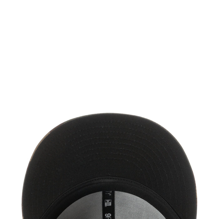 Black baseball cap crown close-up with textured fabric and seam stitching