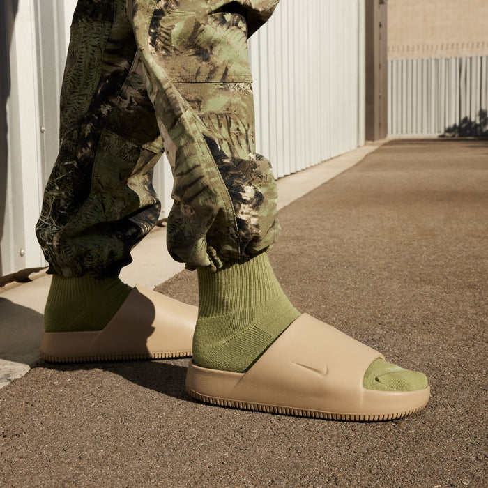 Khaki slide sandals worn with green socks and camo pants