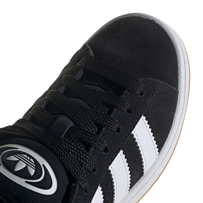 Youth black suede sneaker close-up with 3 white stripes and lace eyelets