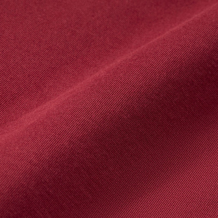 Crimson red knit fabric close-up with fine textured jersey weave