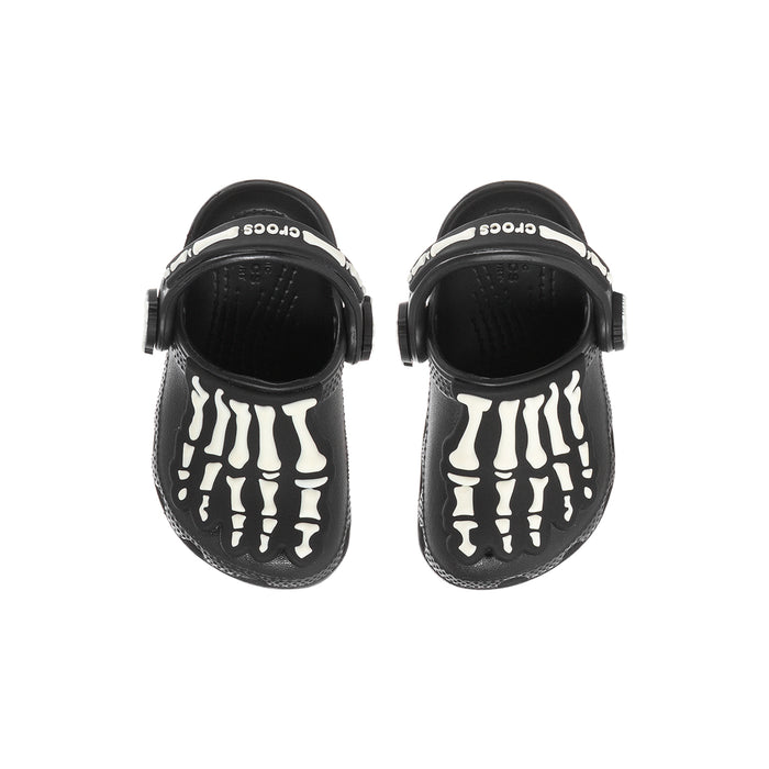 Toddler black clogs with white skeleton bone graphic on top, adjustable heel strap.