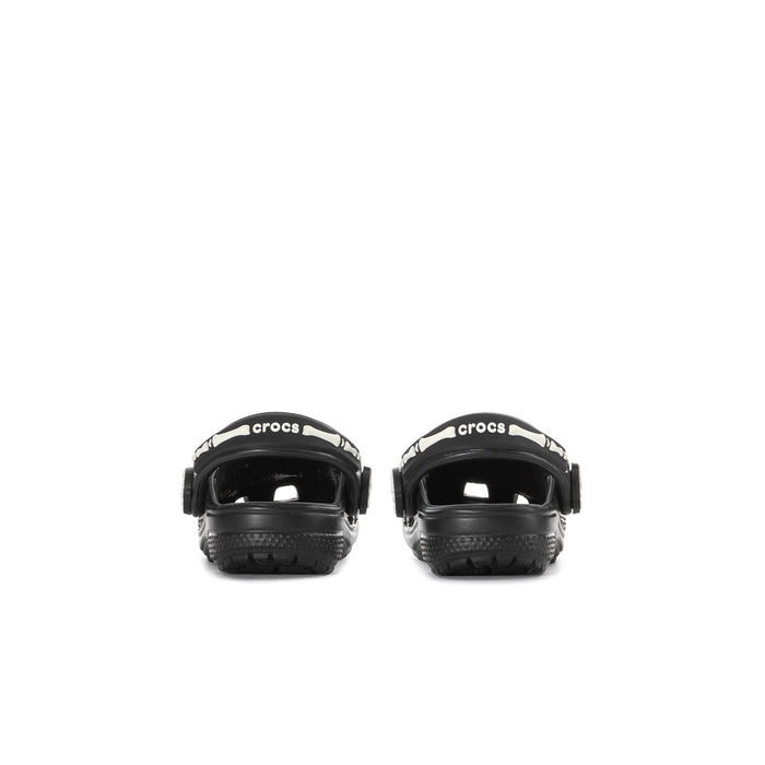 Toddler black clog with white Crocs logo on heel strap and molded back.