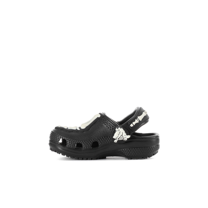 Toddler black clog with white skeleton charm on strap, slip-on comfort fit.