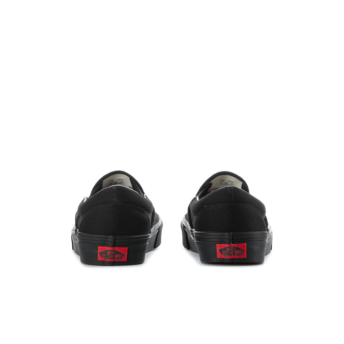 Black slip-on sneakers heel view with red Vans logo patch