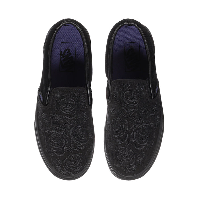 Pair of women's black slip-on sneakers, rose-embossed uppers, front and back