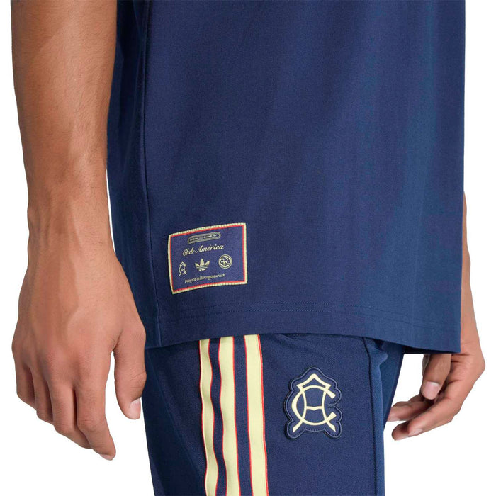 Navy T-shirt hem with woven label patch and gold logo accent