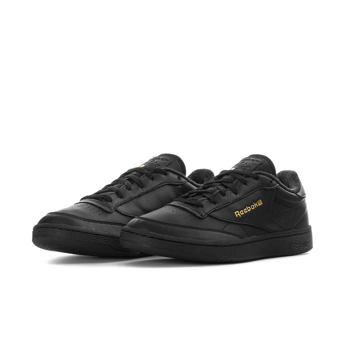 Black leather low-top sneaker with lace-up front and Reebok logo in gold