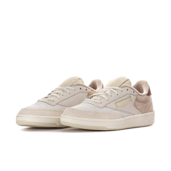 Pair of beige low-top sneakers with brown trim and lace-up design