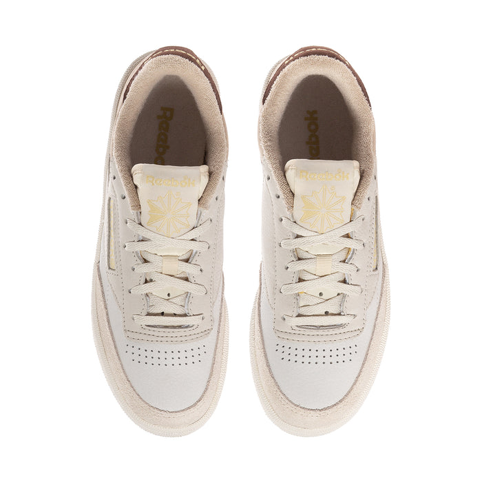 Beige low-top sneakers with lace-up front and Reebok tongue branding