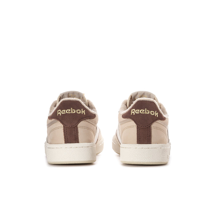 Beige low-top sneakers with brown heel tab and Reebok logo on back