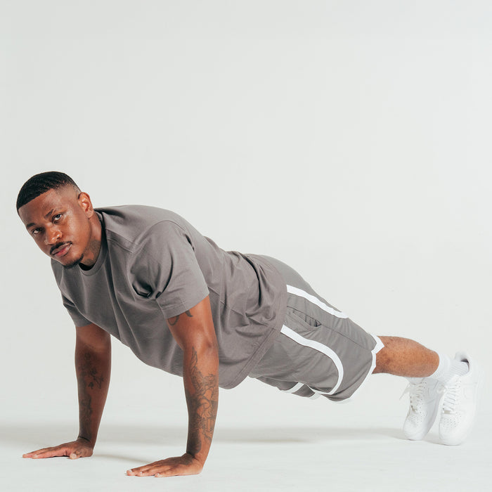 Gray athletic shorts with white contrast tape hem, worn with white crew socks