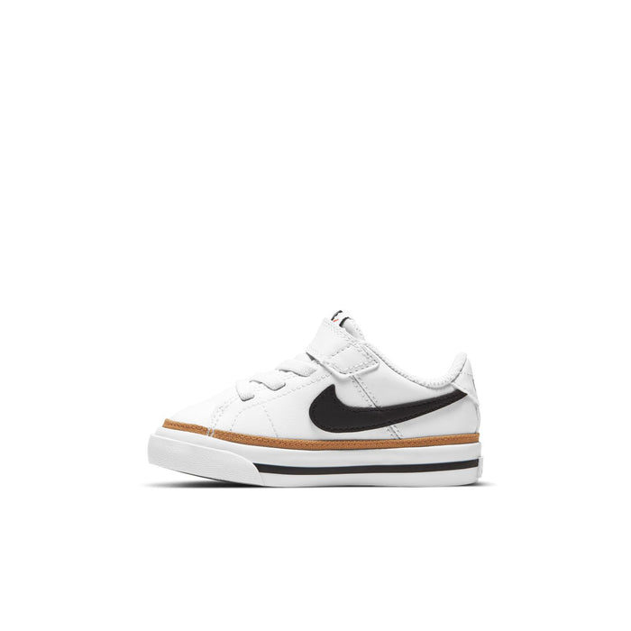 Toddler white sneakers with black NIKE swoosh and tan edge trim