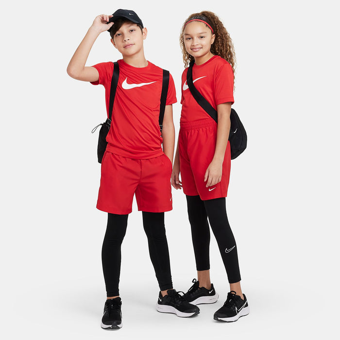 Youth red shorts paired with black leggings and sneakers; elastic waistband and swoosh