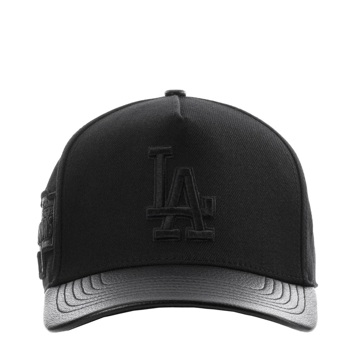 Black pinch-front strapback cap with raised Dodgers 'LA' logo and gray underbrim