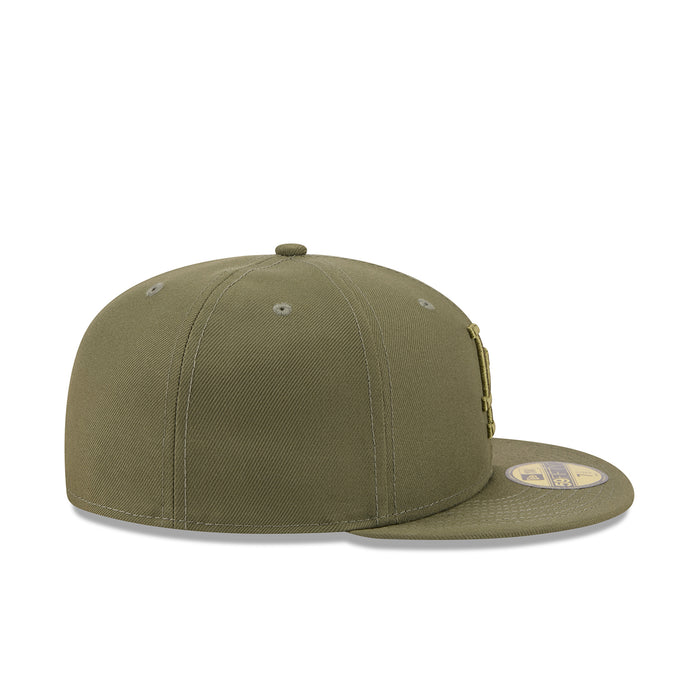Olive baseball cap with stitched panels and small side emblem on brim