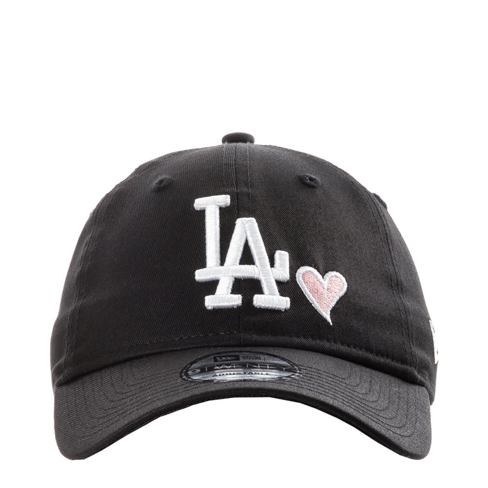 Black baseball cap with white LA logo and pink heart detail on front