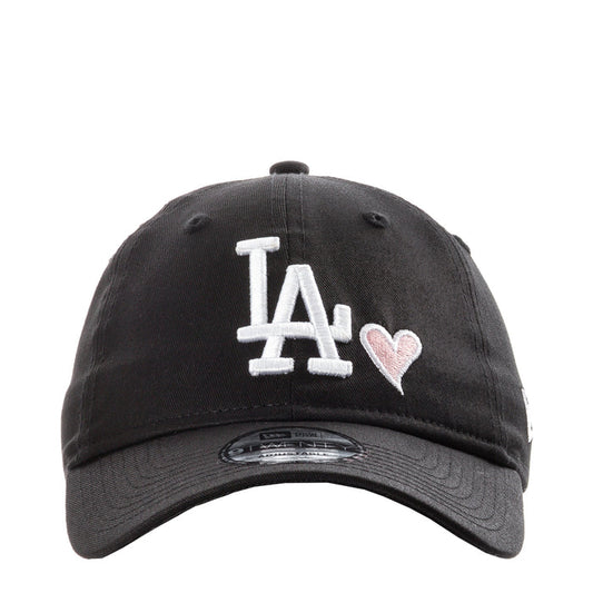 Black baseball cap with white LA logo and pink heart detail on front