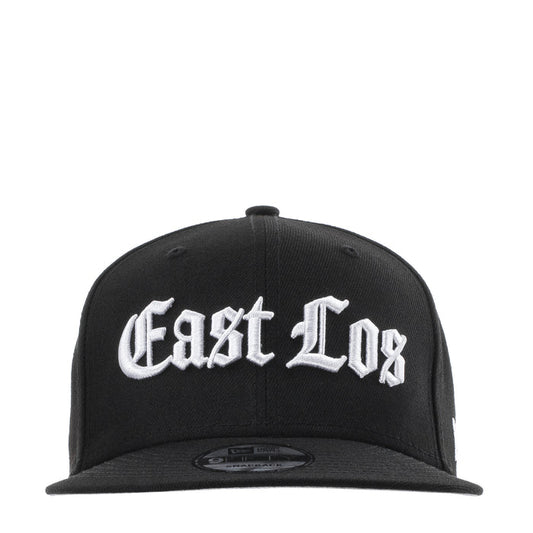 Black baseball cap with white East Los logo; curved brim and snapback strap