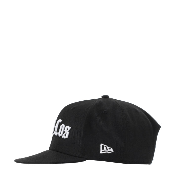 Black baseball cap with white side logo and New Era flag patch; curved brim