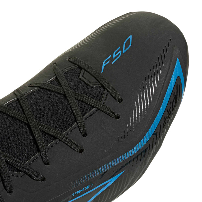 Close-up of men's black soccer cleat upper with blue logo and striped details