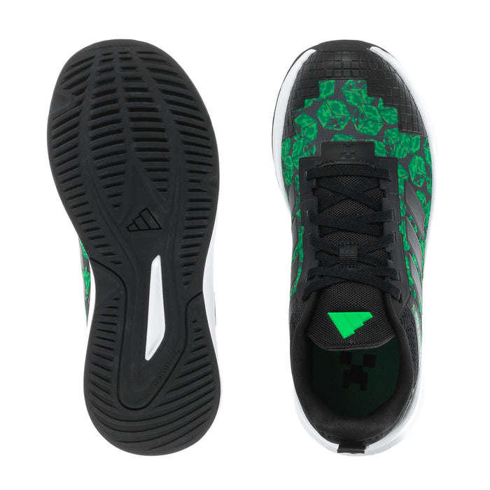 Youth sneaker outsole and heel view, black tread with green graphics and white edge