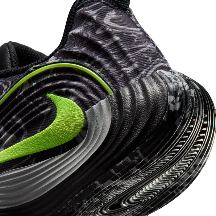 Youth black shoe close-up with volt-green midfoot swoosh and gray traction tread