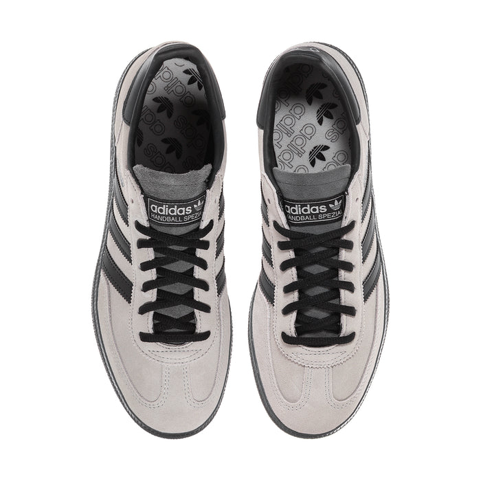 Pair of light gray sneakers with lace-up uppers and dark patterned interior