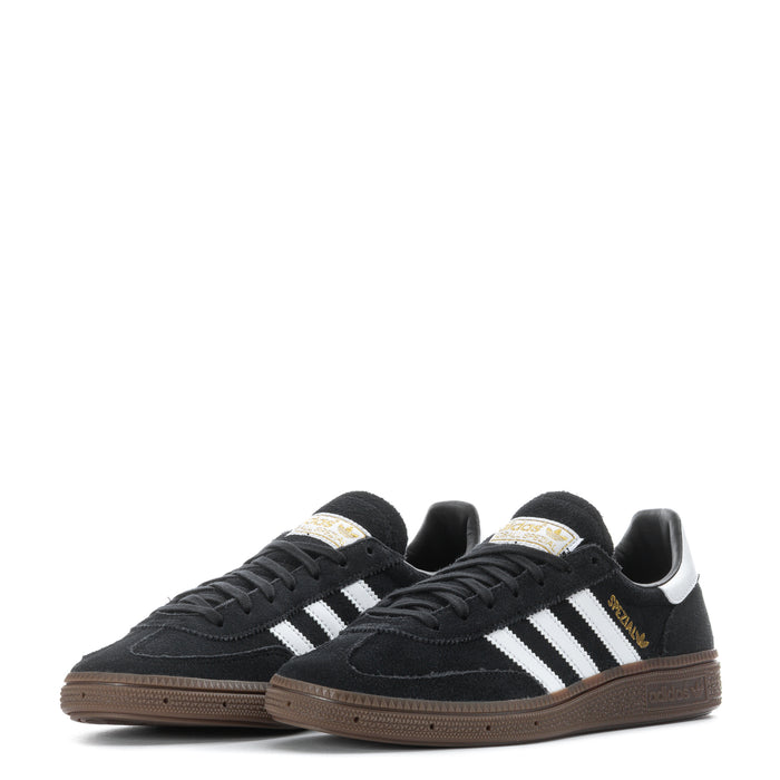 Pair of youth black adidas sneakers with white stripes and gum-colored outsole