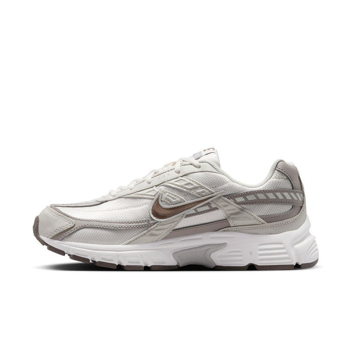 Nike women's running shoes, side view with swoosh logo and gray-brown trim details
