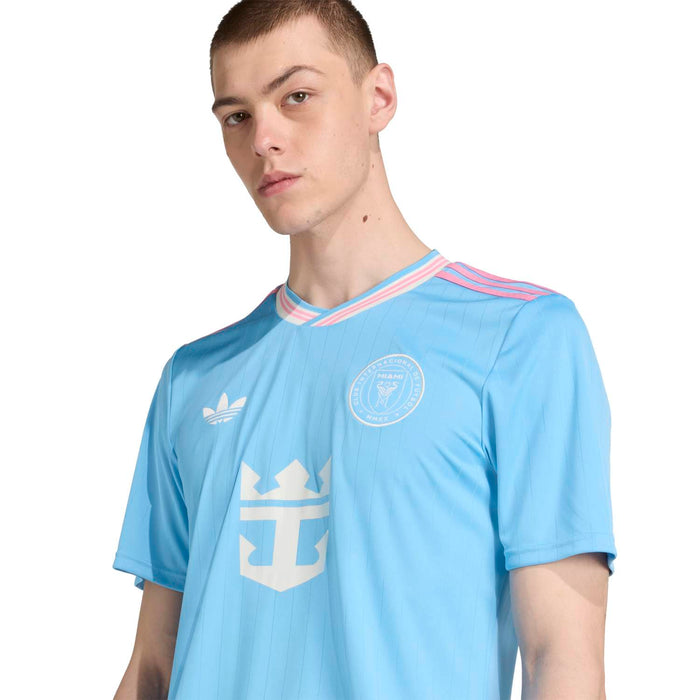 Men's light blue soccer jersey close-up: V-neck, striped collar, front team badge