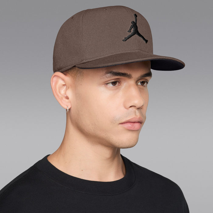 Taupe snapback cap with black Jumpman logo, worn on a model
