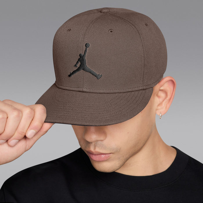 Taupe snapback cap with black Jumpman logo, side view with hand adjusting