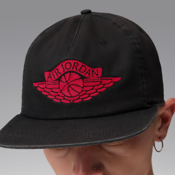 Black cap with red Jordan wings logo, side angle view.