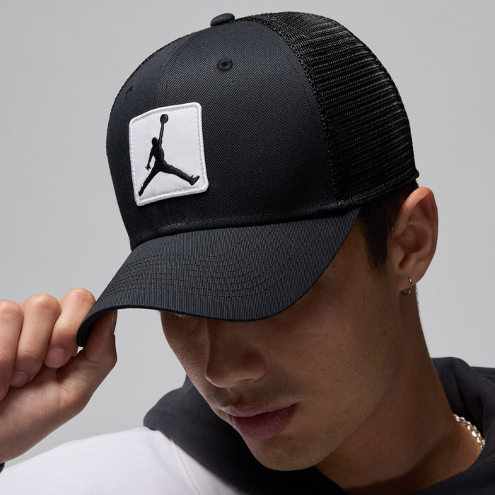 Black trucker cap, side view with white Jumpman patch and curved brim