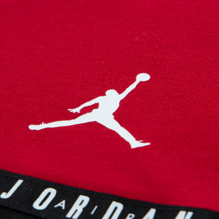 Gym Red T-shirt fabric close-up with white Jordan Jumpman logo and black taping stripe