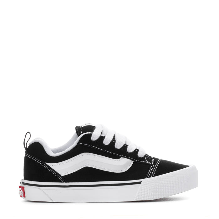 Kids black and white lace-up low-top skate sneakers with white side stripe.