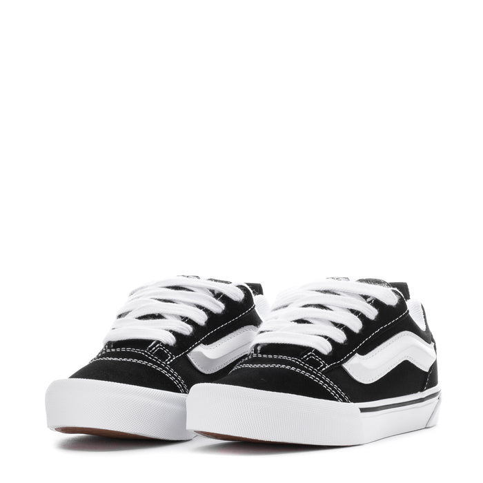 Kids black-and-white lace-up low-top skate shoes, front view with laces.