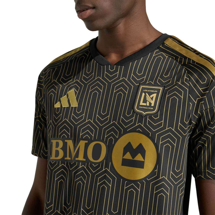 Black jersey close-up with gold geometric pattern, LAFC crest and BMO sponsor