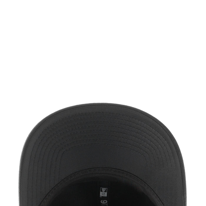 Black baseball cap brim close-up with textured stitched panels
