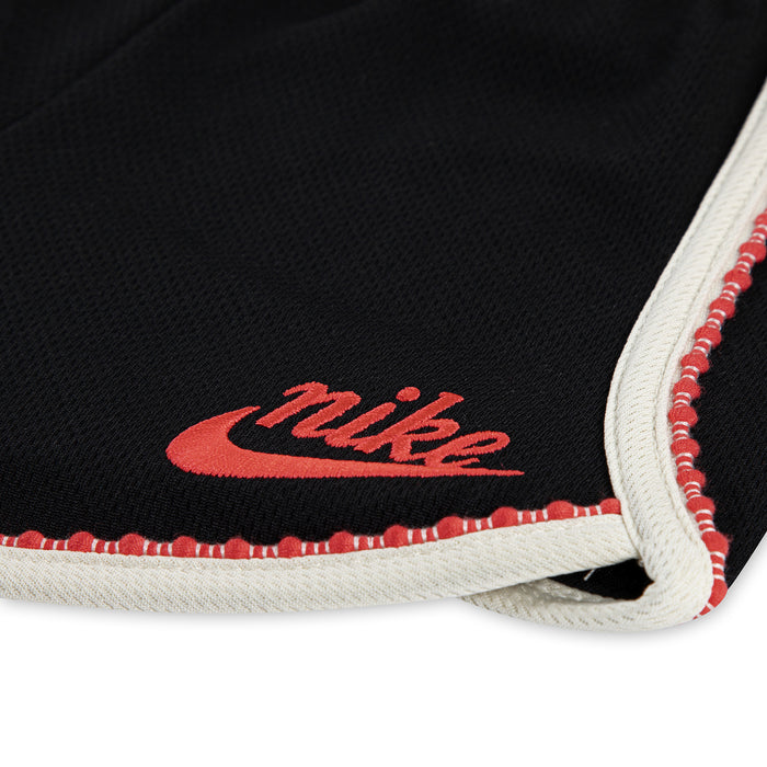 Black toddler shorts hem with Nike logo, red stitch trim and white edge