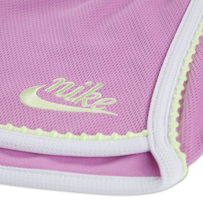 Light magenta toddler short with white trim and neon green logo on hem
