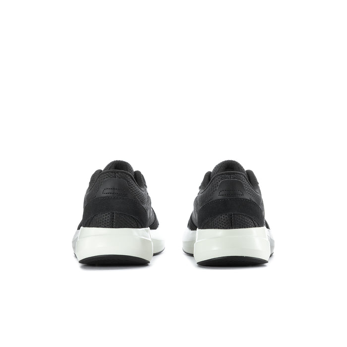 Black sneakers with white midsoles, rear view showing heel support