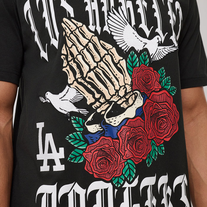 Black T-shirt close-up: gothic hand skull with red roses and green leaves print.