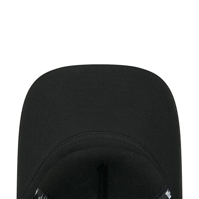 Black baseball cap interior close-up with adjustable strap and small tag