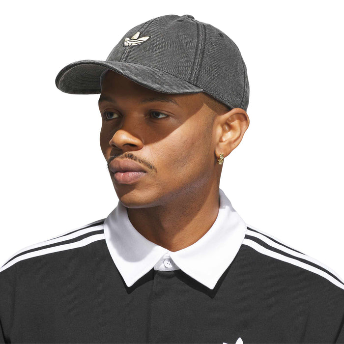 Dark textured strapback cap with small embroidered adidas logo, worn by model