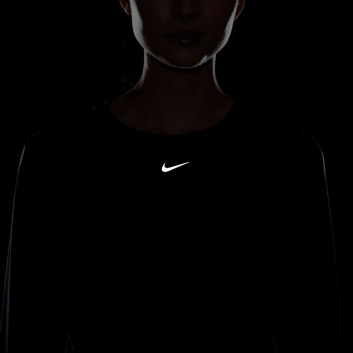 Women's black long-sleeve Dri-FIT top with centered Nike swoosh
