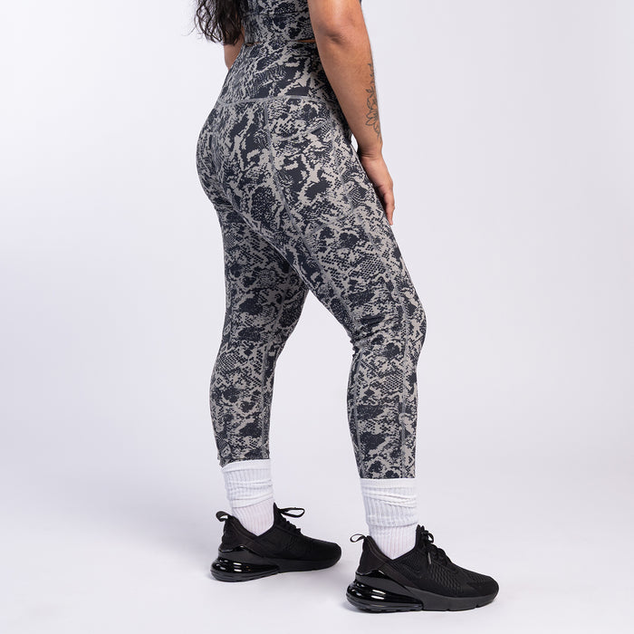 Side view of snake print high-waist leggings in dark gray and black