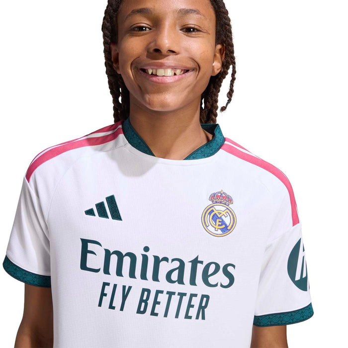 Close-up youth white soccer jersey with Emirates Fly Better text, Real Madrid crest, teal trim